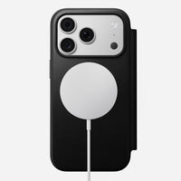 Nomad Modern Leather Folio in black Camino leather for iPhone 18 Pro, back view on a MagSafe charger