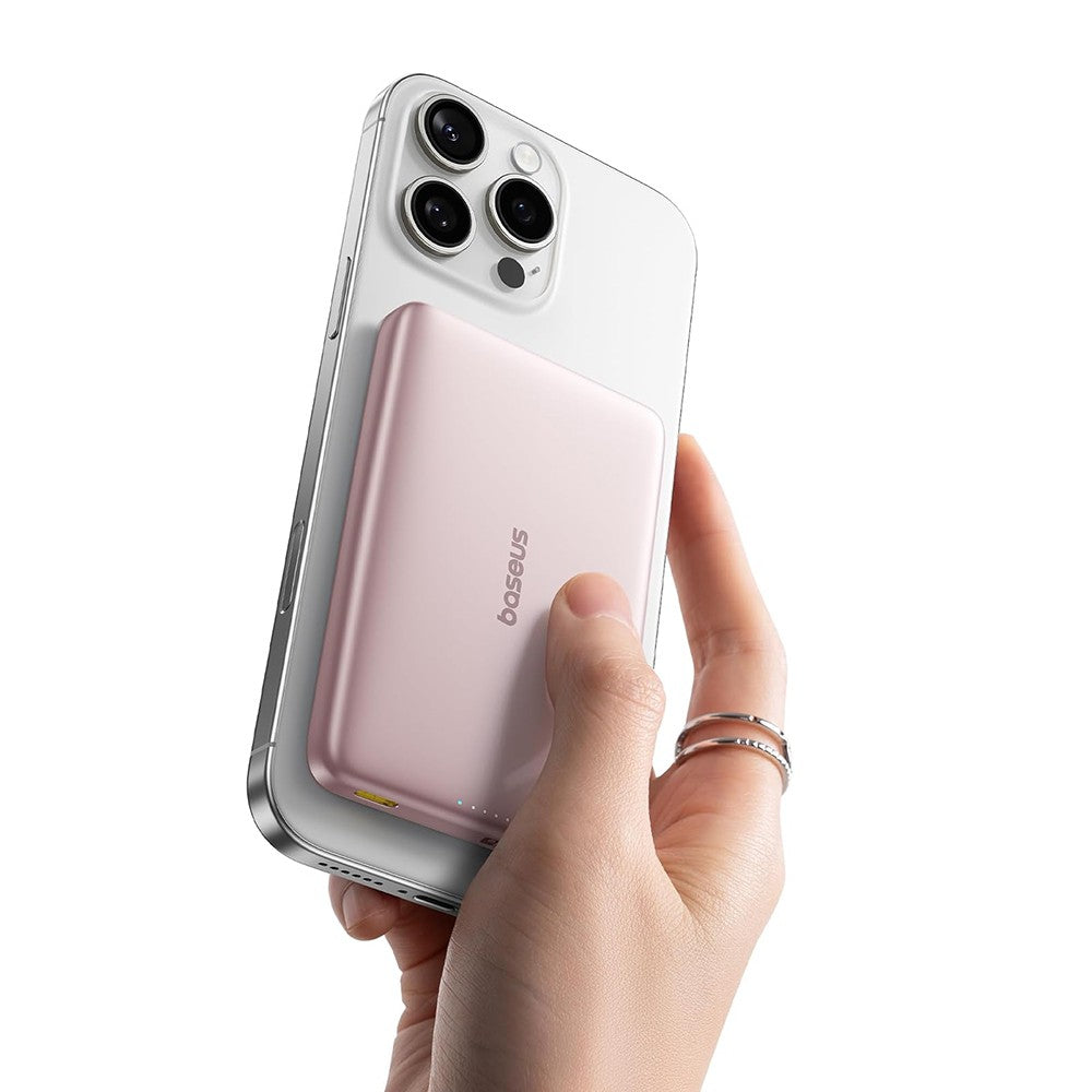 Hand holding a smartphone with a pink case, brand 'baseus' visible